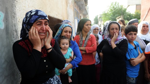 The people of the mainly Kurdish town of Cizre, Turkey, where security forces have battled suspected Kurdish militants, come out of their houses on Saturday.
