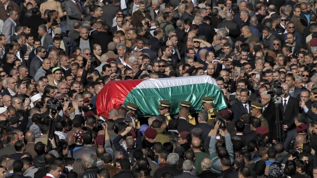 The coffin of Ziad Abu Eid is borne aloft during his funeral in the West Bank city of Ramallah.