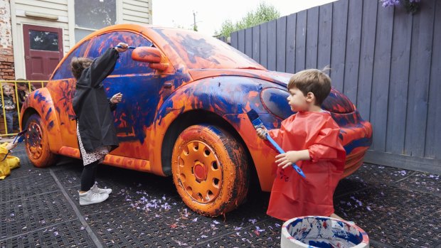 Children painting cars at The Museum of Play and Art (MoPA), Geelong.