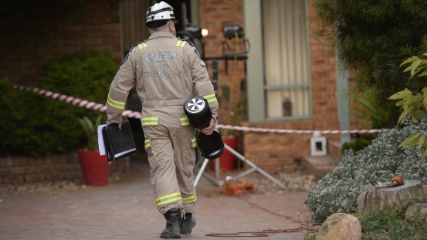 A fire investigator carries a hoverboard of the same make as the one that caused a house fire in Melbourne. 