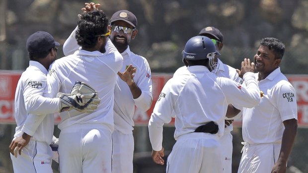 Rangana Herath (extreme right) is congratulated by his teammates after he dismissed Darren Bravo.