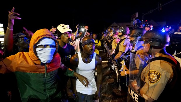 Protesters yell at a police line shortly before shots were fired in a shooting that involved a police officer in Ferguson, Missouri, this month. 