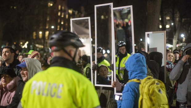 Protesters in Boston hold up mirrors to the police during a protest over the grand jury decision in the Eric Garner case.