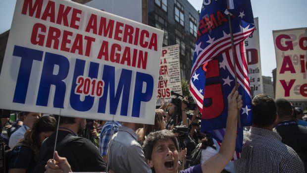 A supporter holds a campaign sign for Donald Trump in the Public Square  in Cleveland.