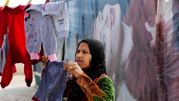 A Syrian hangs her laundry at an informal refugee camp in the Bekaa Valley town of al-Marj.