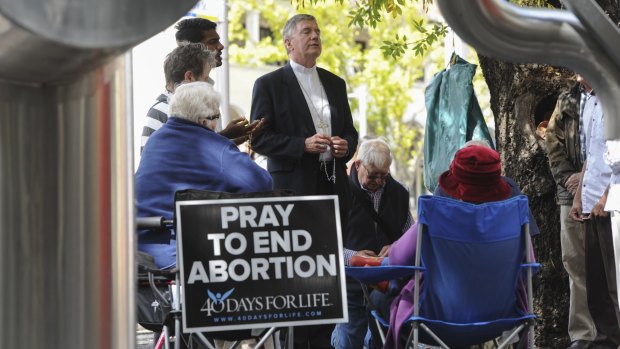 The archbishop joins others in prayer outside an abortion clinic in Civic in 2015.