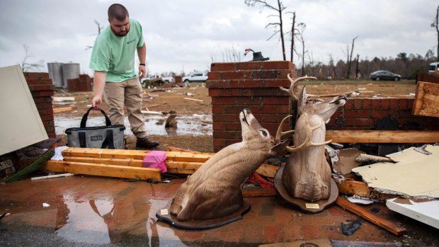 A man cleans up at a home smashed by a tornado on January 22 in Adel, Georgia.