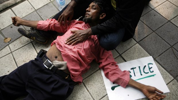 An ethnic Rohingya faints during a rally in Kuala Lumpur.