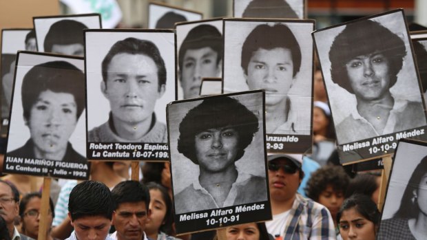 Demonstrators protest against a pardon of former Peruvian president Alberto Fujimori with photographs of people disappeared during his government, in Lima, on Monday.
