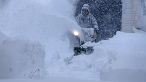 Jerry Delzer attempts to clear the snow in his driveway in Depew, New York.

