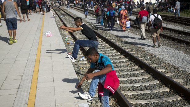 Migrants climb on a platform at a train station in Beli Manastir, near the Hungarian border, in north-east Croatia.