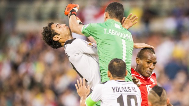 Tawfiq Abuhammad of Palestine give Saad Abdulameer of Iraq an elbow to the face while challenging for the ball.