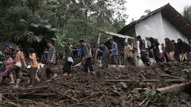 Villagers walk through an area affected by landslides in Banjarnegara, Java, on Sunday.