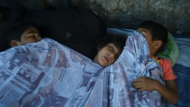 Children sleep on the floor outside the station. 