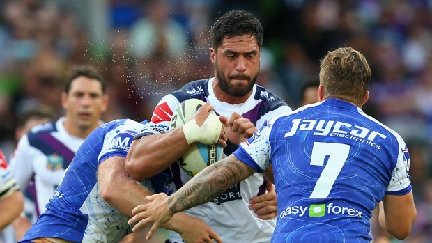 Determined: Jesse Bromwich is tackled by Canterbury Bulldogs players at AAMI Park. 