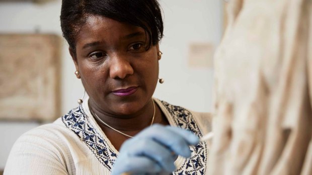 British Museum senior conservator Michelle Hercules uses a "mechanical swab" to clean a marble sculpture. 