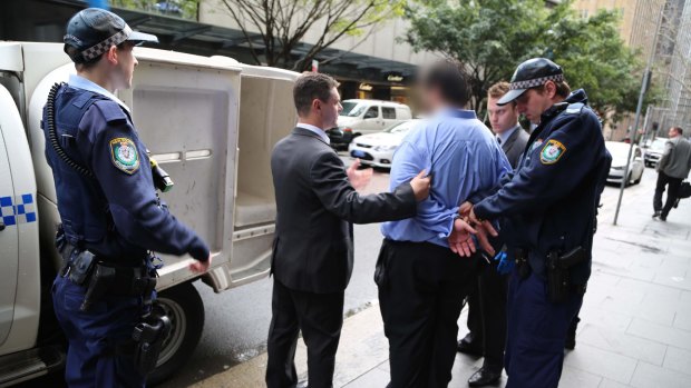 Police lead the 34-year-old man from a Martin Place office.
