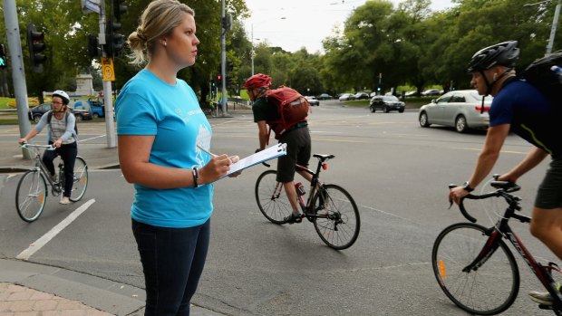 Volunteer Sarah Morrison records cyclists on their way to work on Super Tuesday. 