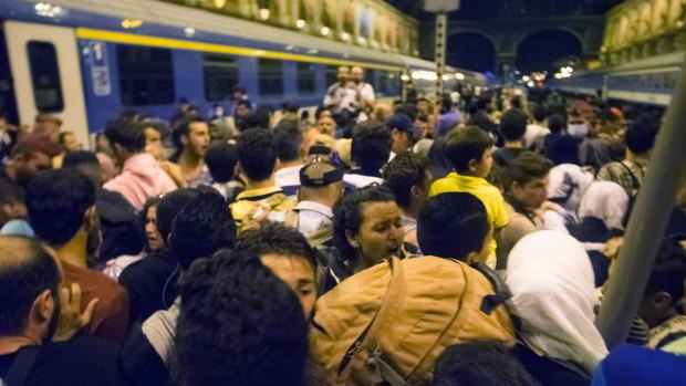 Migrants wait to board a train to Germany.