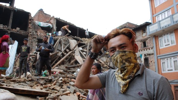 Sanjiv Basujala, 23, survived the collapse of his house, but two people on the floor below died. He is now trying to clear the rubble by hand.