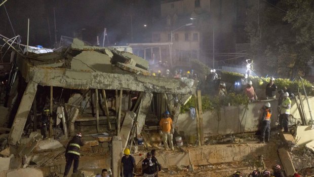 Volunteers and rescue workers search for children trapped inside at the collapsed Enrique Rebsamen school in Mexico City.