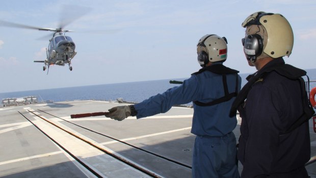 Japan sailors guide a Philippine Navy helicopter as it lands on the deck of the Harusame during a joint naval exercise less than 300 kilometres from a Philippine-claimed shoal now under Chinese control in the South China sea.