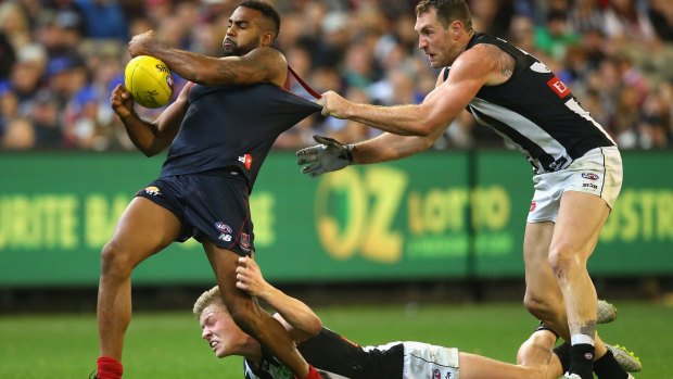 Going nowhere: Heritier Lumumba of the Demons is tackled by Jordan De Goey and Travis Cloke of the Magpies.
