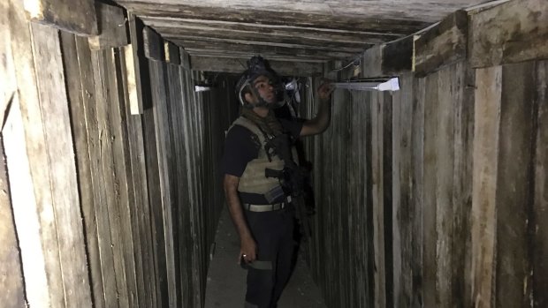 A soldier with Iraq's elite counterterrorism force inspects a tunnel made by IS in Bartella, Iraq.