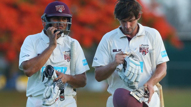 In thought: Queensland players Usman Khawaja and Joe Burns of the bulls leave the field at the end of play.