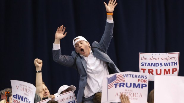 A supporter of Republican presidential candidate Donald Trump tries to pump up the crowd before the Chicago rally was cancelled on Friday.