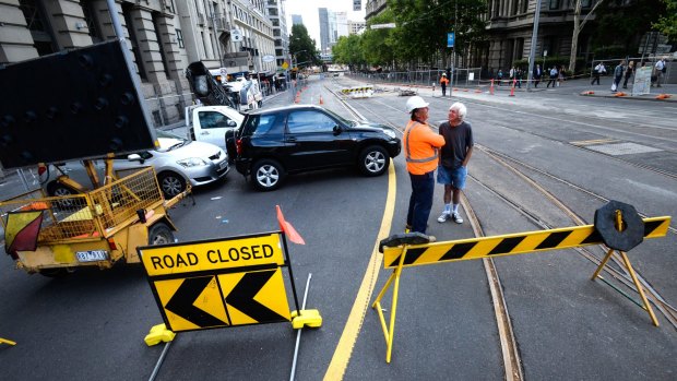 Closed: Workers build a new tram stop near the corner of Flinders and Spencer streets, causing traffic chaos.