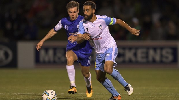 Sky Blues the limit: Alex Brosque of Sydney FC breaks away from Michael Reeve.