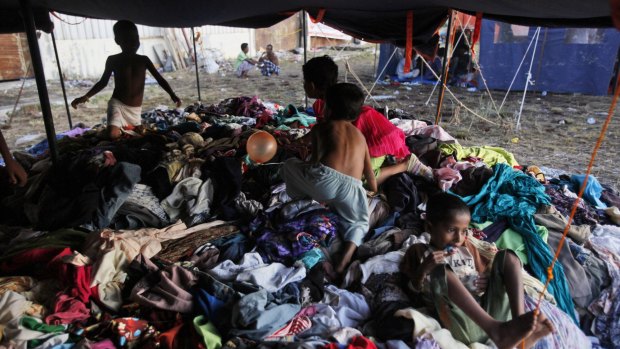 Ethnic Rohingya children play on a pile of clothes donated by local residents at a temporary shelter in Langsa, on Monday.