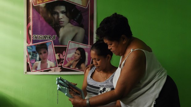 In hiding Elena de Chavez, right, with her daughter Arriana de Chavez look at a photo of her transgender daughter Heart.