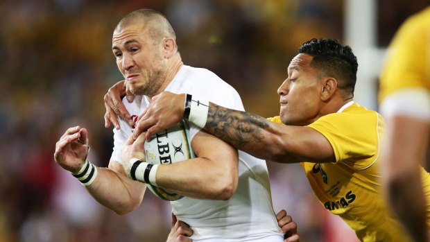 Slippery customer: Mike Brown tries to escape the clutches of Israel Folau.