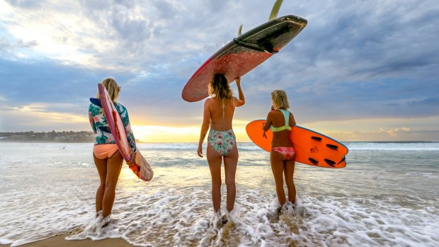 Bondi locals from left, Sheryne Horton, Avis Mulhall and Olivia Phyland check the surf at Bondi at first light. 