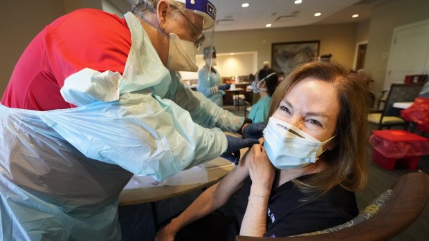 Healthcare worker Pam Peter, right, prepares to receive her second round of a COVID-19 vaccine in Florida.