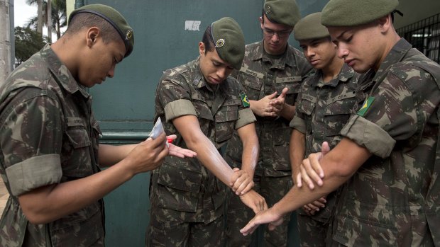 Army soldiers apply insect repellent as they prepare for a clean-up operation against the Aedes aegypti mosquito in Sao Paulo. 