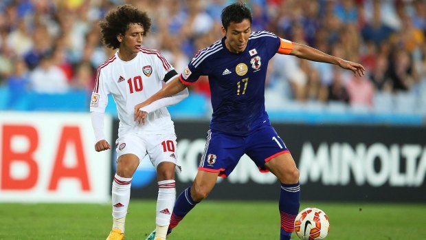 Omar Abdulrahman of the United Arab Emirates competes with Makoto Hasebe of Japan during the Asian Cup quarter-final which the UAE won.