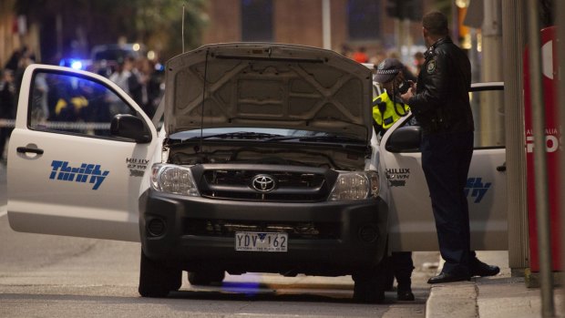 Police check a ute of a man who made a threat on Phillip Street in Sydney. 