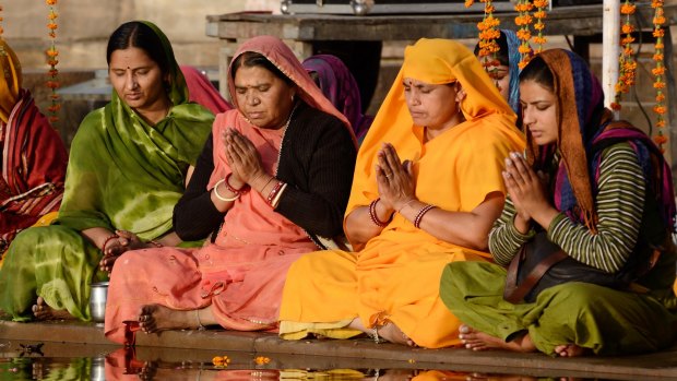 Women perform puja - ritual ceremony at holy Pushkar Sarovar lake.