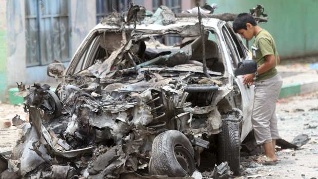 A boy looks at the wreckage at the site of a car bomb in Yemen's capital Sanaa earlier this week.