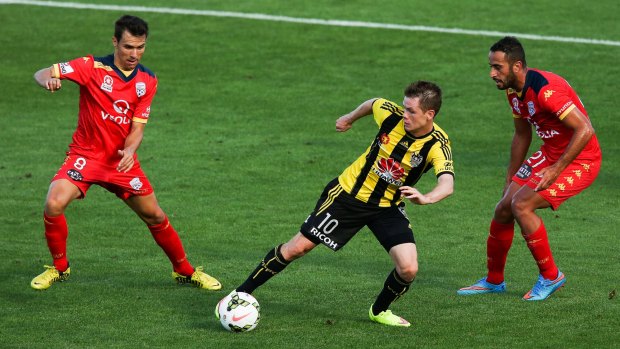 In control: Phoenix midfielder Michael McGlinchey evades Adelaide United defenders Isaias and Tarek Elrich during Wellington's 2-0 victory.