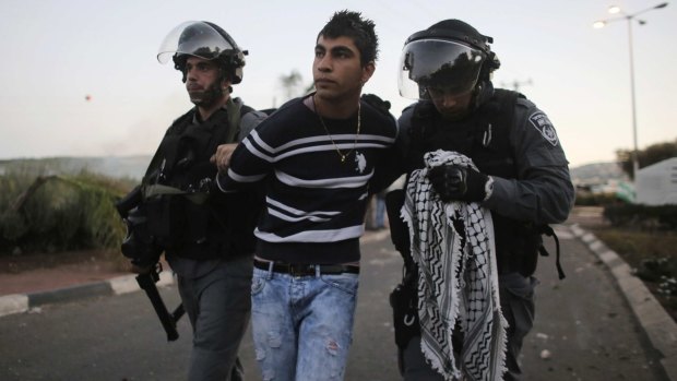 Israeli policeman detain an Arab youth during clashes at Kafr Kanna in the Galilee on Saturday.