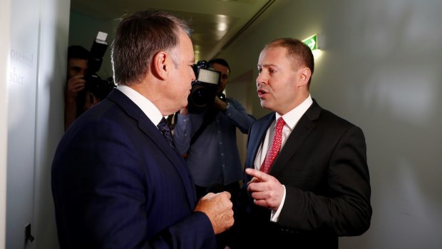 Environment and Energy Minister Josh Frydenberg has an argument with Labor MP Joel Fitzgibbon on energy issues as they cross paths at Parliament House.