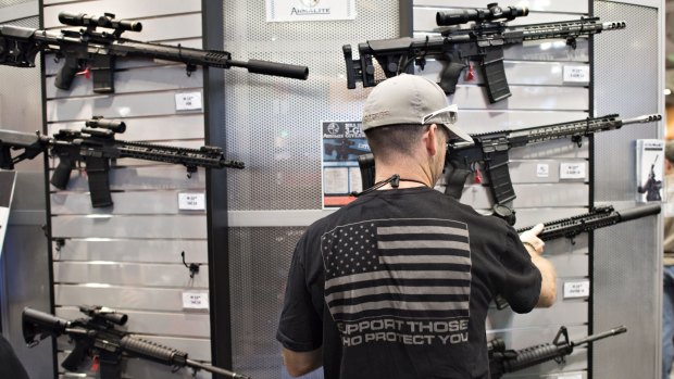 An attendee looks over rifles in the ArmaLite booth at the 144th National Rifle Association (NRA) annual meetings in Nashville in April.