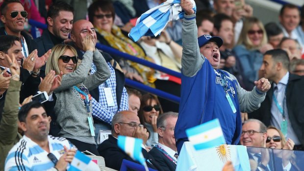 Support:  Diego Maradona celebrates in the stands.