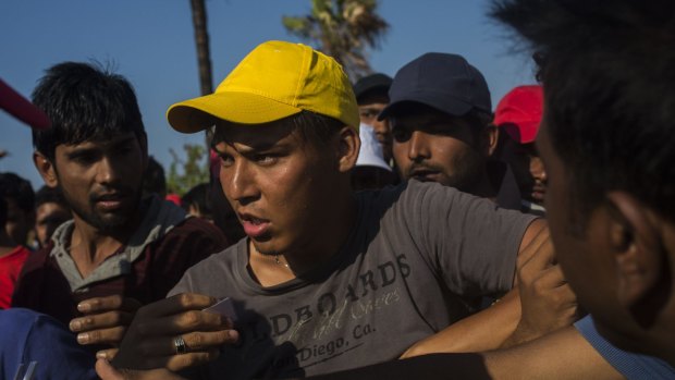 An Afghan scuffles with other migrants to get a meal from volunteers on the Greek island of Kos this week. 