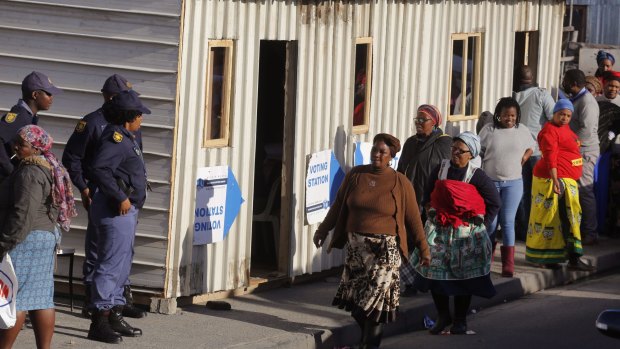 South African police outside a polling station during municipal elections in Khayelitsha township.