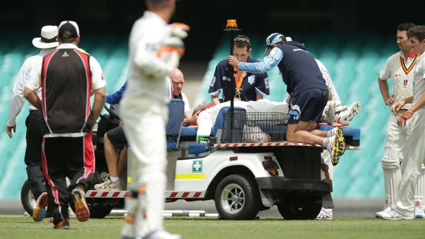 John Orchard, at the rear, works on Phillip Hughes at the SCG. 